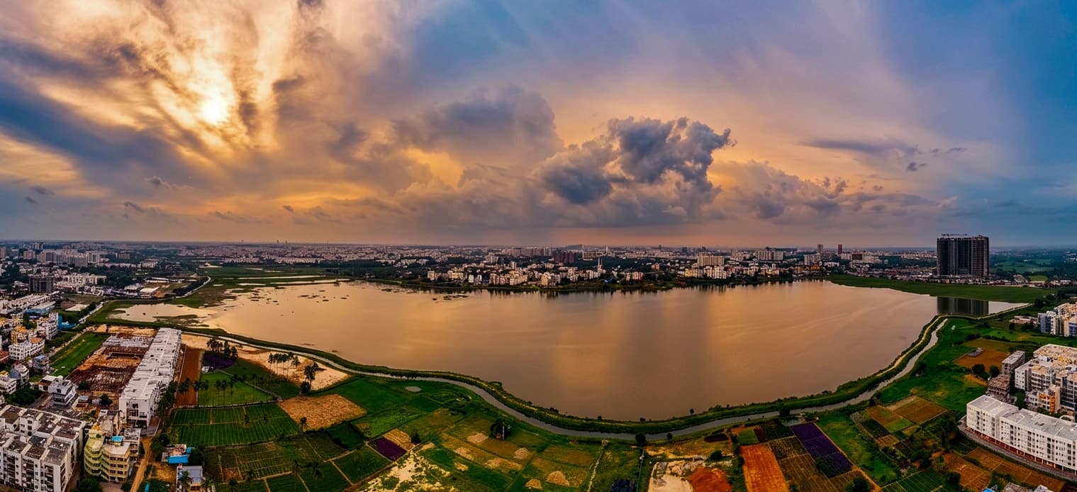 Aerial photograph of Varthur Lake at sunset, with Whitefield beyond the far shore